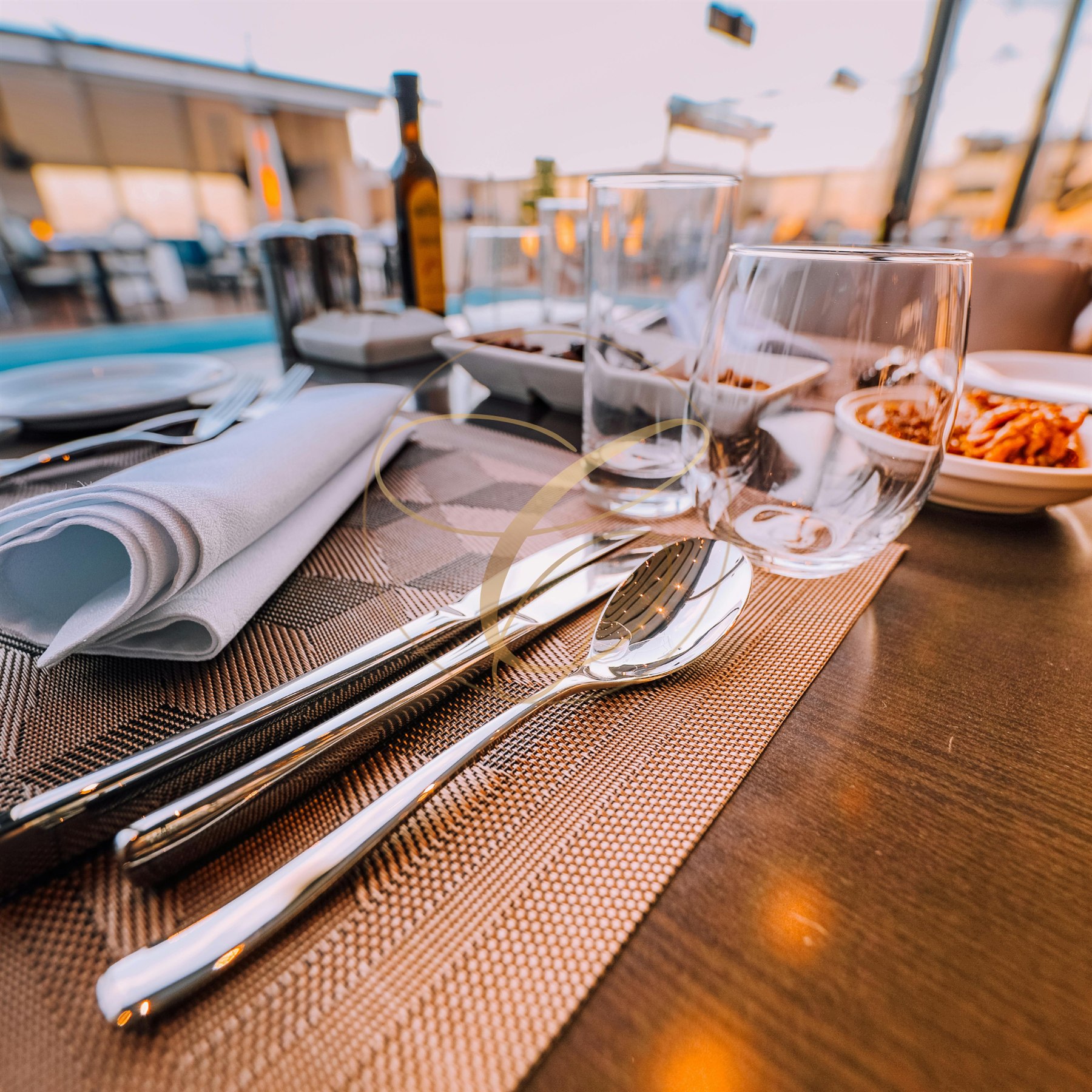 Table de restaurant soigneusement dressée, marquée du filigrane Connivence